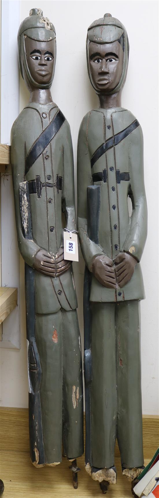 A pair of West African carved colonial figures tallest 118cm